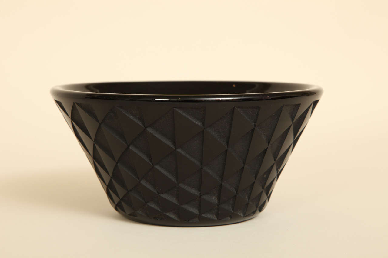 This bowl has etched glass triangles in a geometric pattern with repeated decoration around the body.

Jean Luce (1895-1964) worked as a designer in a cubist-inspired style, rejecting the use of too much design and figurativeness in decoration. He