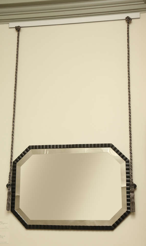 Octagonal bronze frame with hemi-cylinders all around and reed support on either side for suspension. Suspended with steel bullion rope with tassels. Mirror is bevelled.