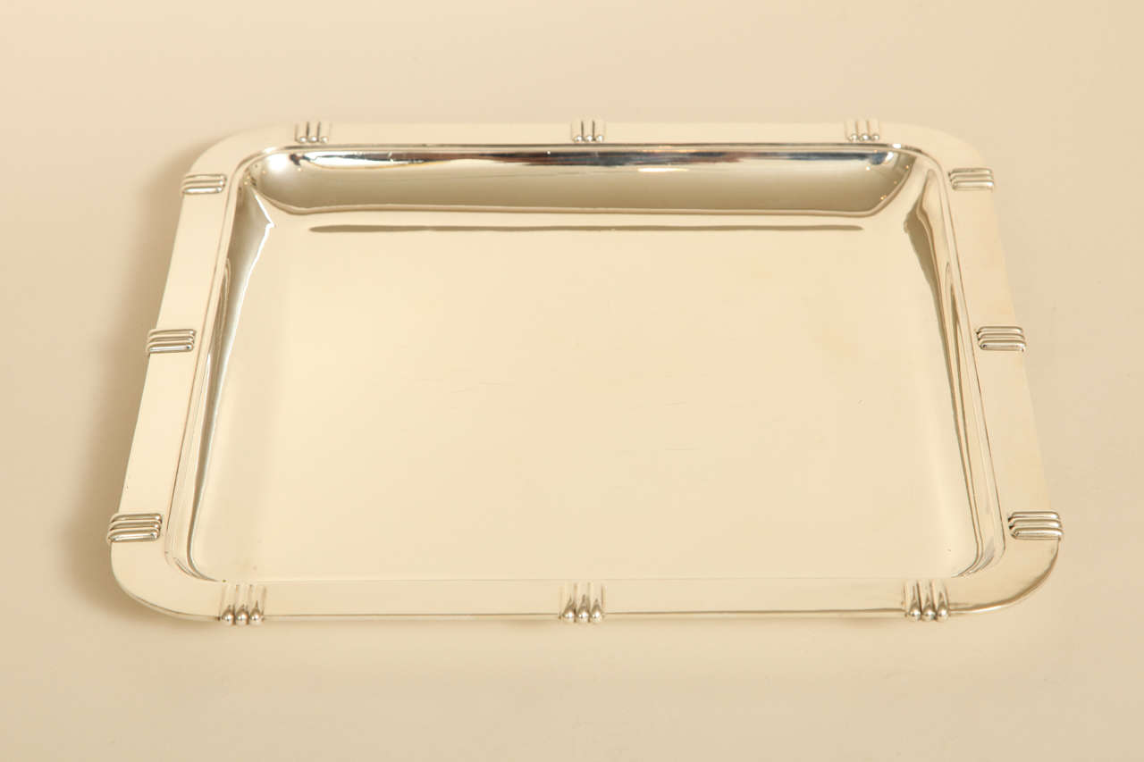 Large square silver serving tray with a flat rim decorated by repeating pattern of three vertical bands by Jean Puiforcat (1887-1945).
Hallmarks: 950 silver/ Jean E. Puiforcat/EP penknife.

Other Puiforcat pieces available.