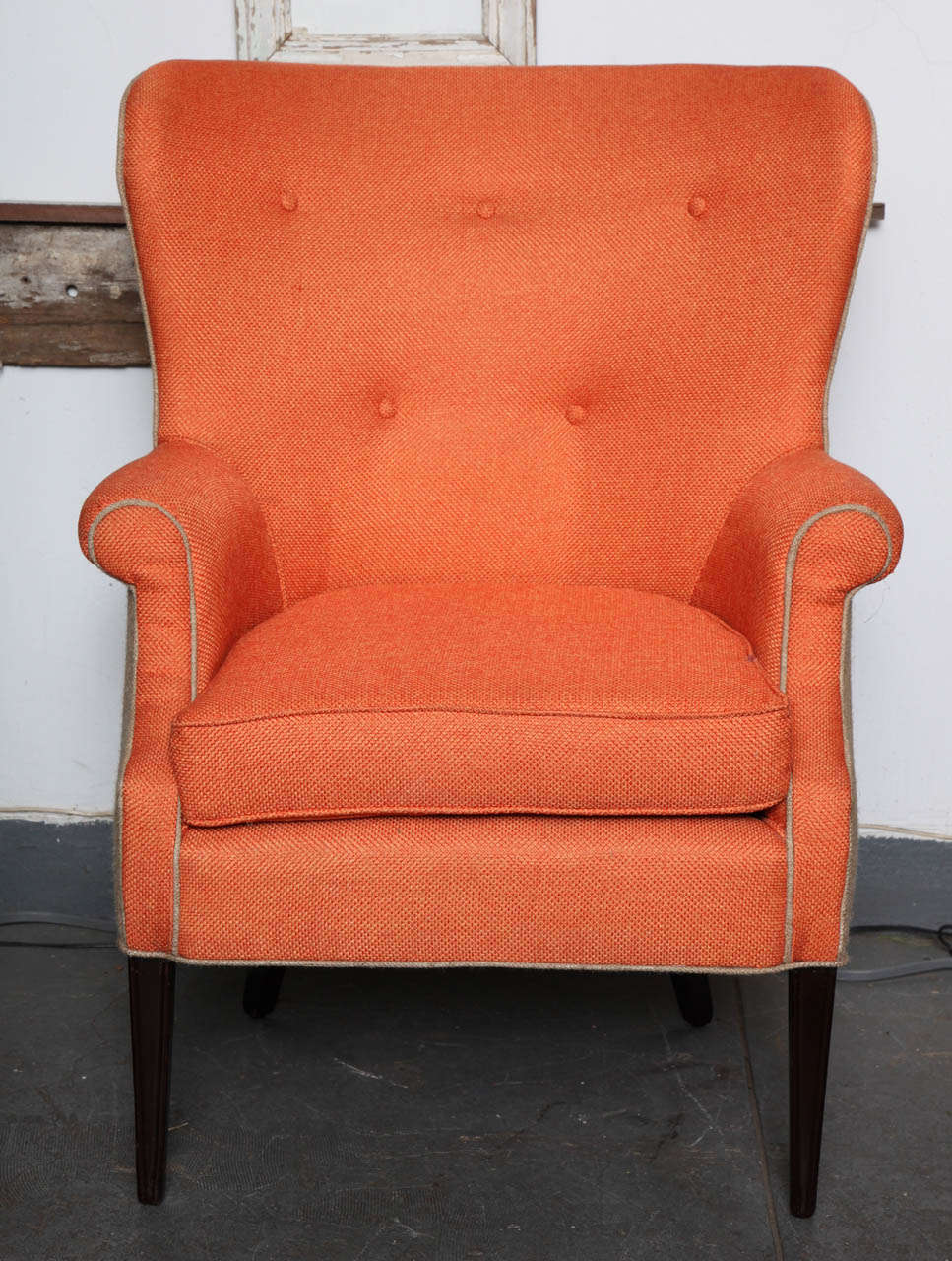 This Scandinavian Wingback chair was updated with jute fabrics in the front in orange and in the back in neutral color. It has its original solid mahogany legs and was updated keeping its originally designed tufted back.