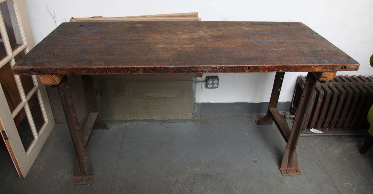 This Antique Kitchen table is original with all the nips and tucks that she carries from all the years in use. It received updated supported pine slabs underneath its top. It keeps its original iron base. The table was part of a kitchen in a farm in