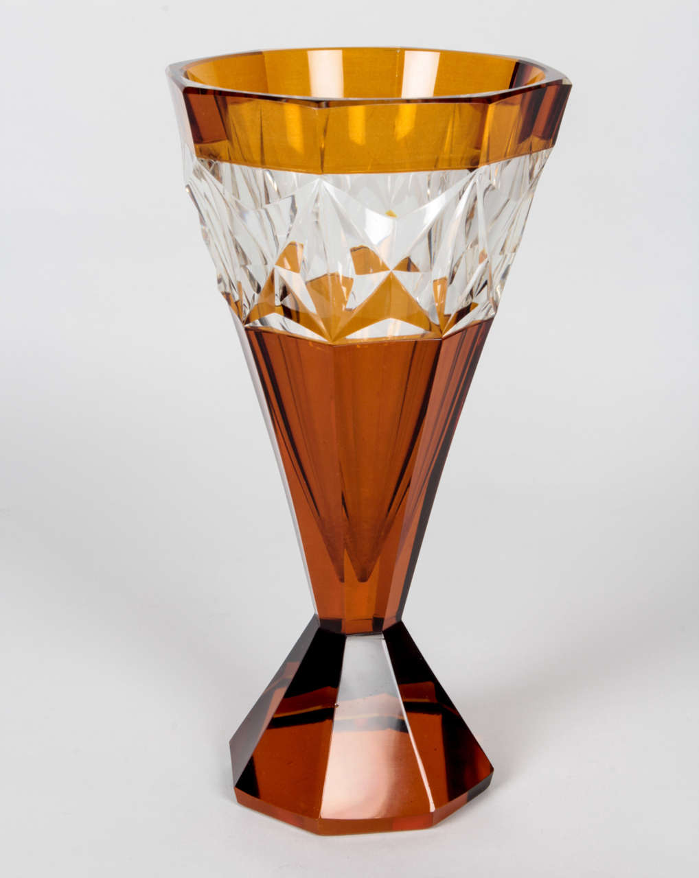 CZECH CUBISM / ART DECO 

Panel-cut vase   c. 1912-25	

Clear cut lead crystal with amber overlay in conical form with a band of chevron cut designs around the upper third; the conical form above a flaring, paneled foot 

For more information