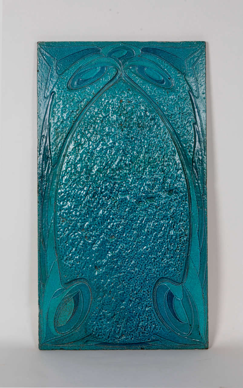 HECTOR GUIMARD  (1867-1942) France
MAISON COILLIOT Lille, France

Tile c. 1898

Fired and glazed lava with abstract whiplash motifs in various tones of aqua blue on the obverse and a partial graphic on the reverse with polychrome floral and