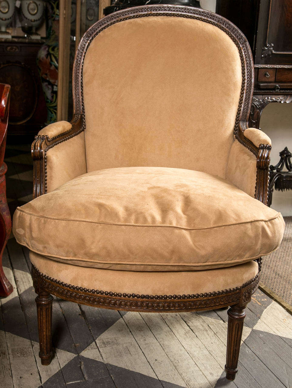 this large scale pair of bergeres are now upholstered in ultra suede and  one has an unfortunate  hole  on the  front of the back.
Extremely comfortable and  well proportioned. Carved walnut frame  with an arched back and padded arms. Fluted 