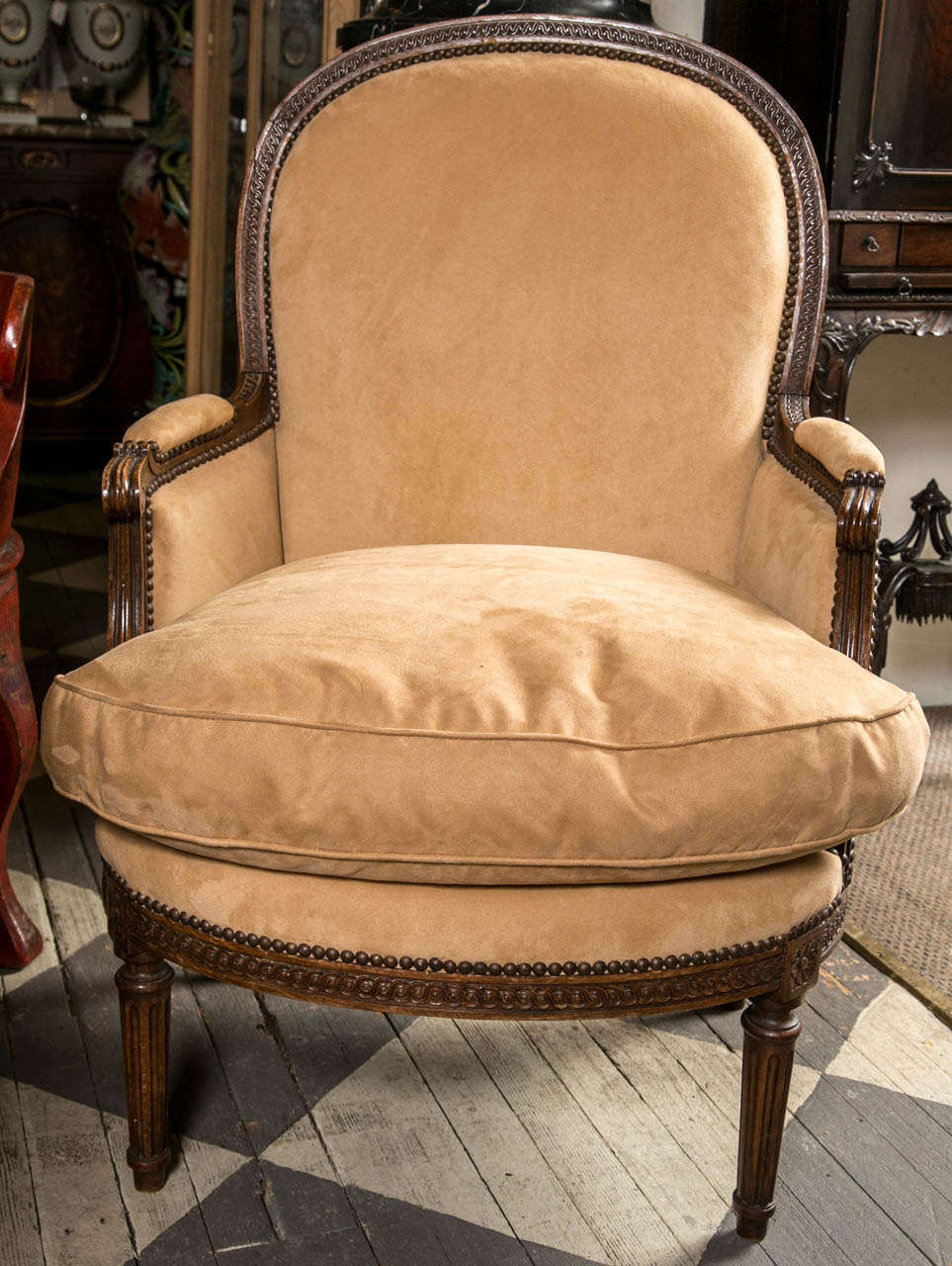 cette paire de bergères à grande échelle est maintenant tapissée de daim ultra et de coton  on a un malheureux  trou  sur le  l'avant de l'arrière.
Extrêmement confortable et  bien proportionné. Cadre en noyer sculpté  avec un dos arqué et des bras