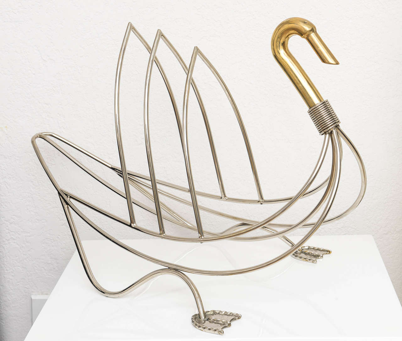 Chrome and brass swan shaped magazine rack.

Please feel free to contact us directly for a shipping quote or any additional information by clicking 