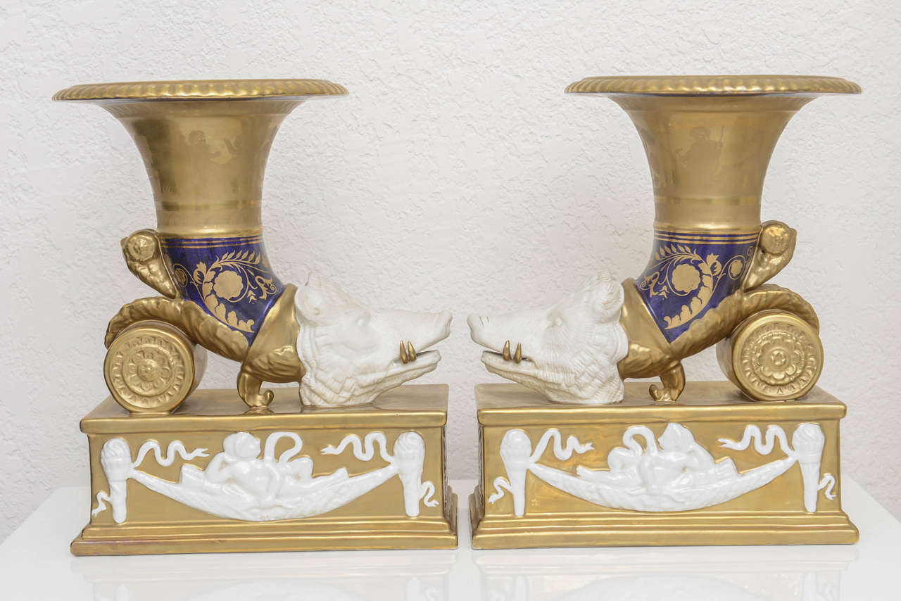 This stylish pair of cornucopia were acquired from a Palm Beach estate and date the mid-19th century in Dresden, Germany. The Classic motif of a boars head, cherubs, swags, acanthus leaves and festoons all in glazed 18-karat gold, cobalt and white
