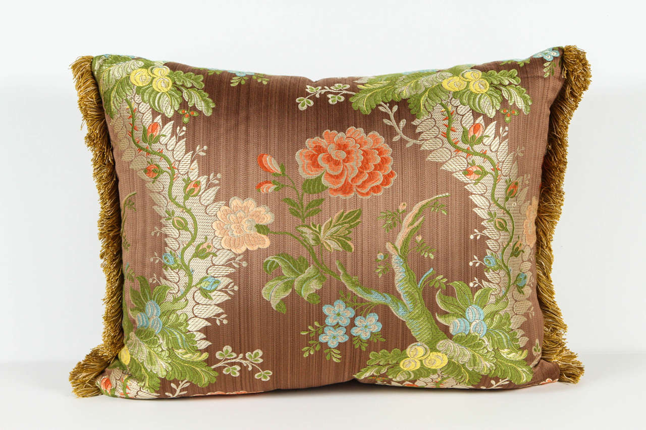 Throw pillow in a botanic motif fabric with fringe.