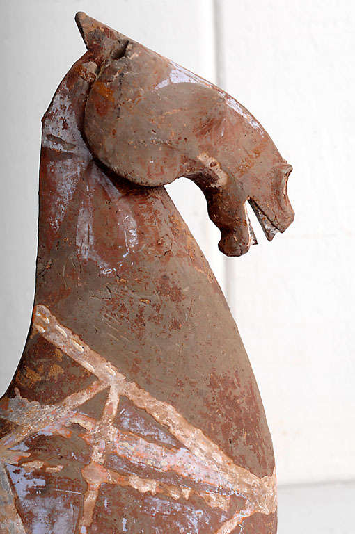 Ancient Chinese Artifact of a Recumbent Pottery Horse with traces of original polychrome paint in subdued pastel shades presented on clear acrylic base. Excavated from the tombs of China's Ruling Class.