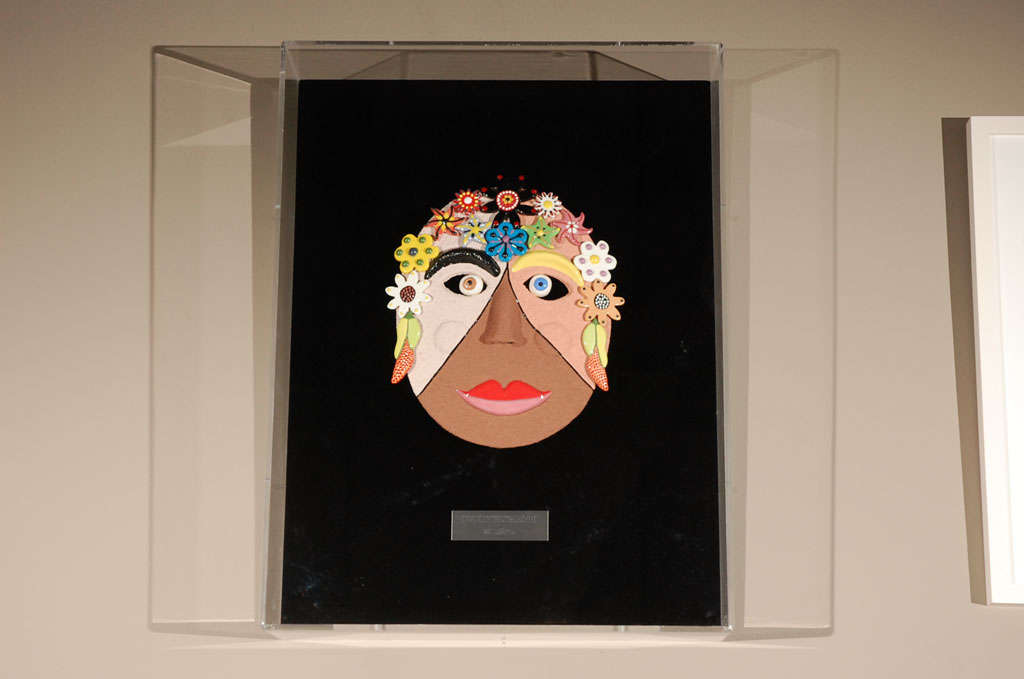 A colorful ceramic mask by famed artist George Marlowe entitled Every Woman II. Every mask is a unique piece of art and is not duplicated. Mask is mounted on black velvet and framed in a clear Lucite Box with a black background. Mask size is