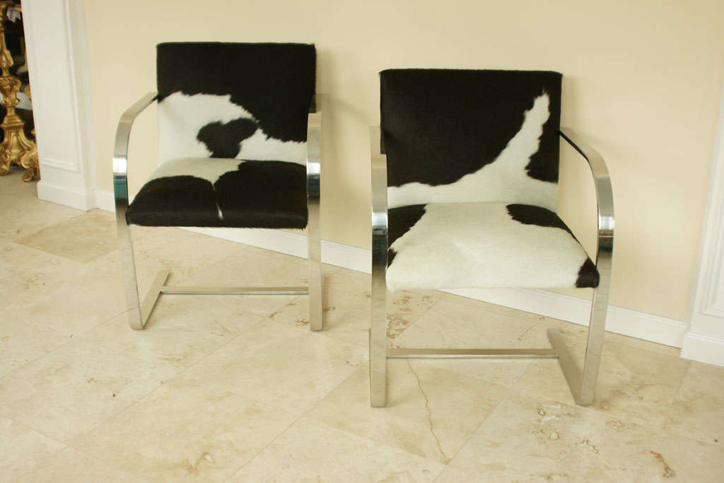 Beautifully executed pair of black and white cowhide chairs with a polished chrome frame.