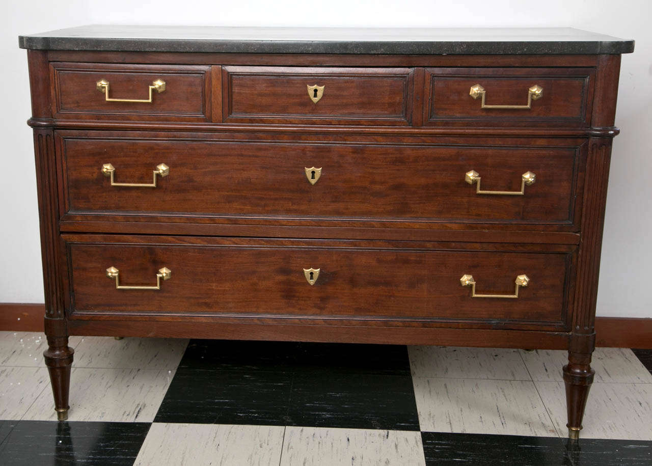 More subdued than some, this commode still manages to grab one’s attention and is perfectly capable of commanding a room or foyer. From the fossilized marble top (look closely) to squared brass drawer pulls with hexagonal back plates and reeded side