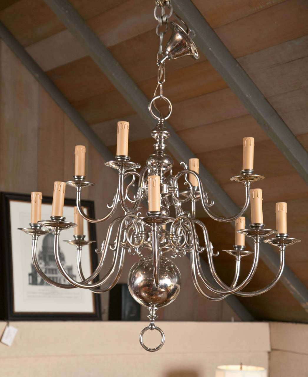 Instead of the more common six-over-six setup of arms, this chandelier opts for four-over-eight, allowing for a lower (closer to the table) distribution of light. Coated in a shiny layer of nickel, it also breaks from the golden brass tradition,