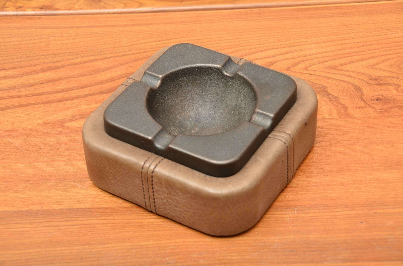 Heavy Bronze Ashtray sitting in pigskin wrapped casing with baseball stitch detail on seams.