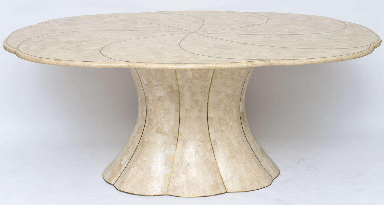 We love the pretty scalloped form of this impressive dining table by Maitland Smith. Neutral petrified coral tiles inlaid with solid brass detailing.