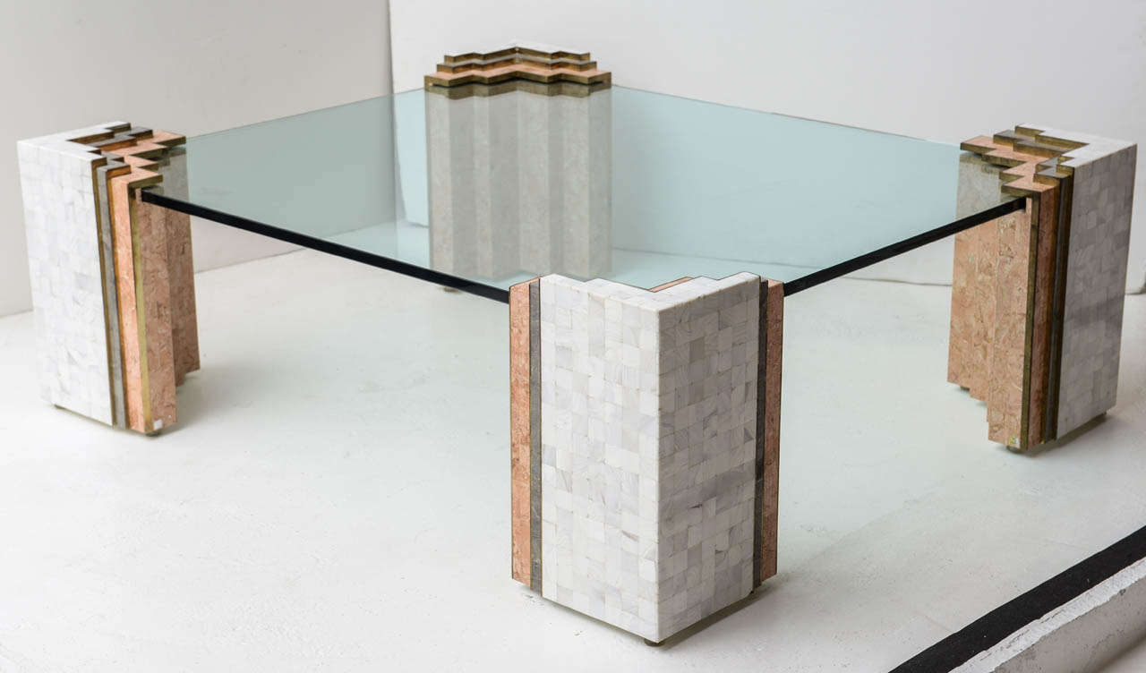 Glass-topped coffee table by Maitland Smith has 3/4-inch glass supported by four piers fashioned from brass and tessellated stone in soft tones of white, grey and peach.
