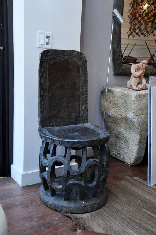 20th century carved African chair. Please note:Chair seat has a crack and repair which does not compromise the integrity of the piece nor affect the stability.
