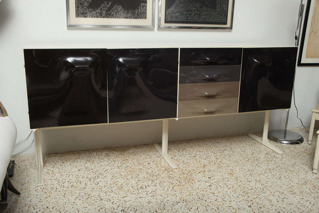 Designed by Raymond Loewy and produced in France for Doubinsky Freres, this very desirable credenza features injection-molded plastic door and drawer fronts in the rarer taupe-to black colorway (with the added surprise of orange and yellow on the