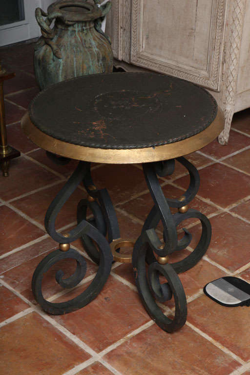 A very heavy cast iron black painted and gilt gueridon table with four scroll legs.<br />
The bottom legs extend 1 inch from the top of the table.