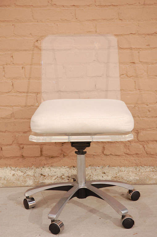 Lucite desk chair with brushed chrome swivel base with linen upholstered seat cushion.