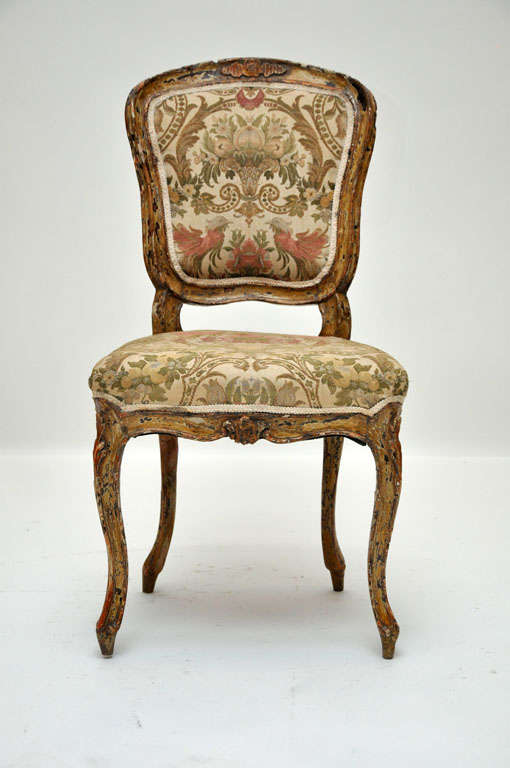 Pair of French Louis XV style boudoir or side chairs. Intricately carved frame with foliate motifs, cartouche and slightly arched framed back above a shapely serpentine seat, floral silk upholstery, supported on front cabriole legs and outswept back