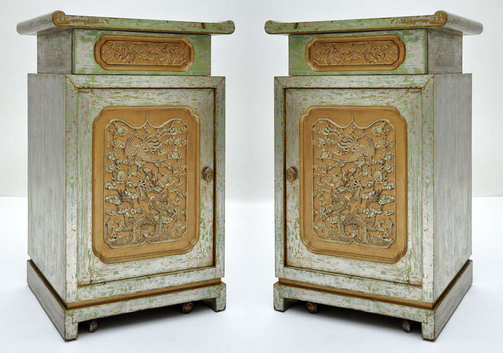 Pair of Chinese modern end cabinets in the manner of James Mont. Extraordinary gold and silver gilt finish over painted green pecan. Front doors adorned with Chinese style gold filigree panel depicting carved mythological Chinese dragon and Phoenix