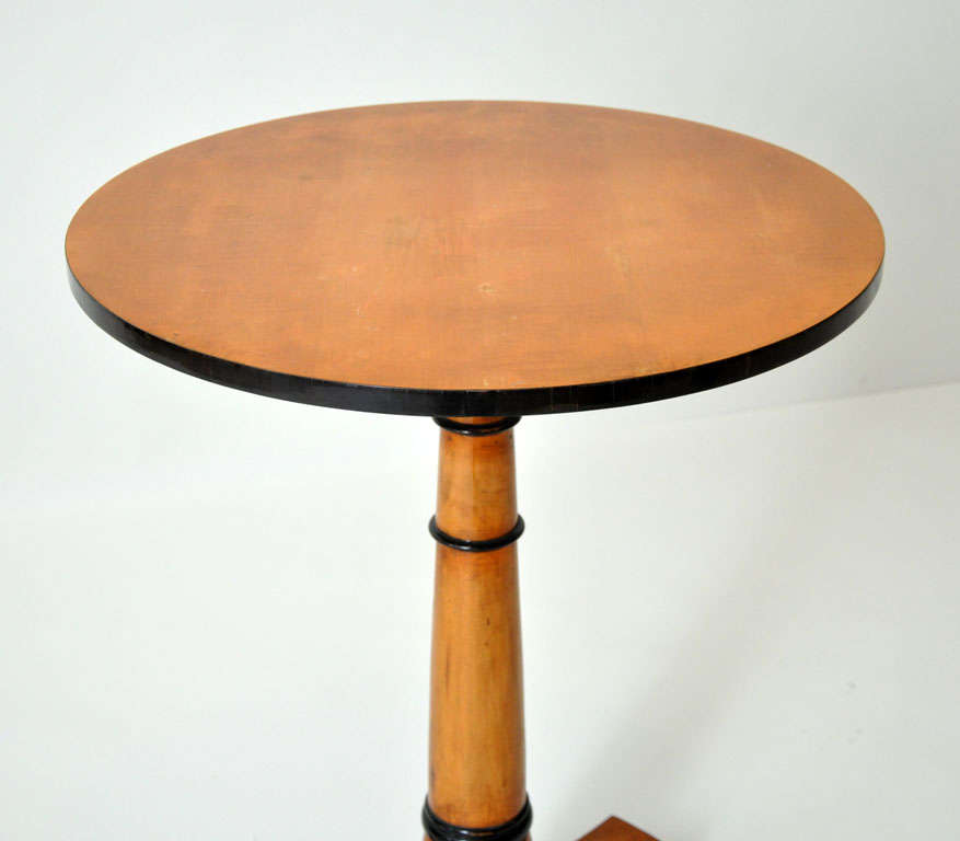 Unique pair of small Austrian Biedermeier cherry side tables or occasional tables with exquisite French polish finish. Circular top surface with ebonized trim border, supported by a ring turned cylindrical column pedestal support resting on a
