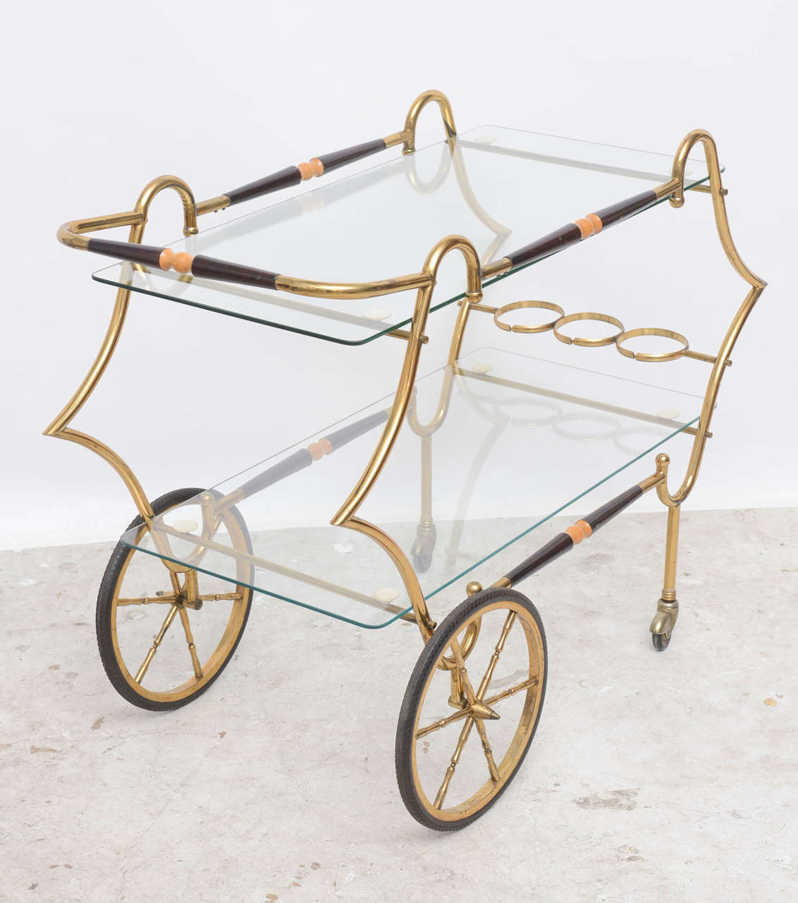 1950s Italian brass and glass trolley serving or bar cart, two-tiered with bottle rests, stretcher side bars upper and lower tier and push handle is of brass and honed mahogany. A modern interpretation or take of the Georgian period in style and