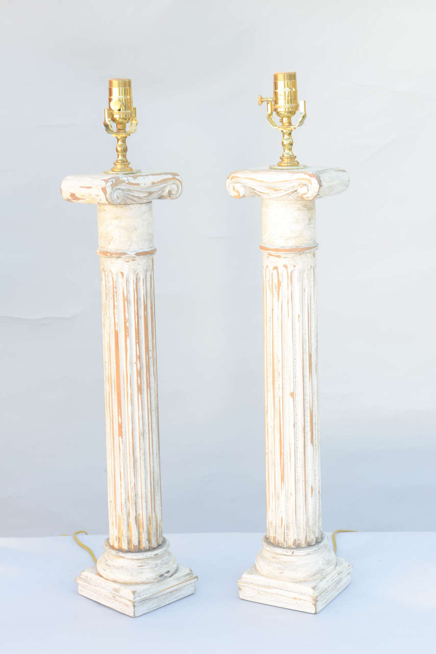 Paire de lampes, en bois, chacune ayant une finition peinte en blanc vieilli ; les deux colonnes cannelées avec chapiteaux ioniques.

Stock ID : D8050