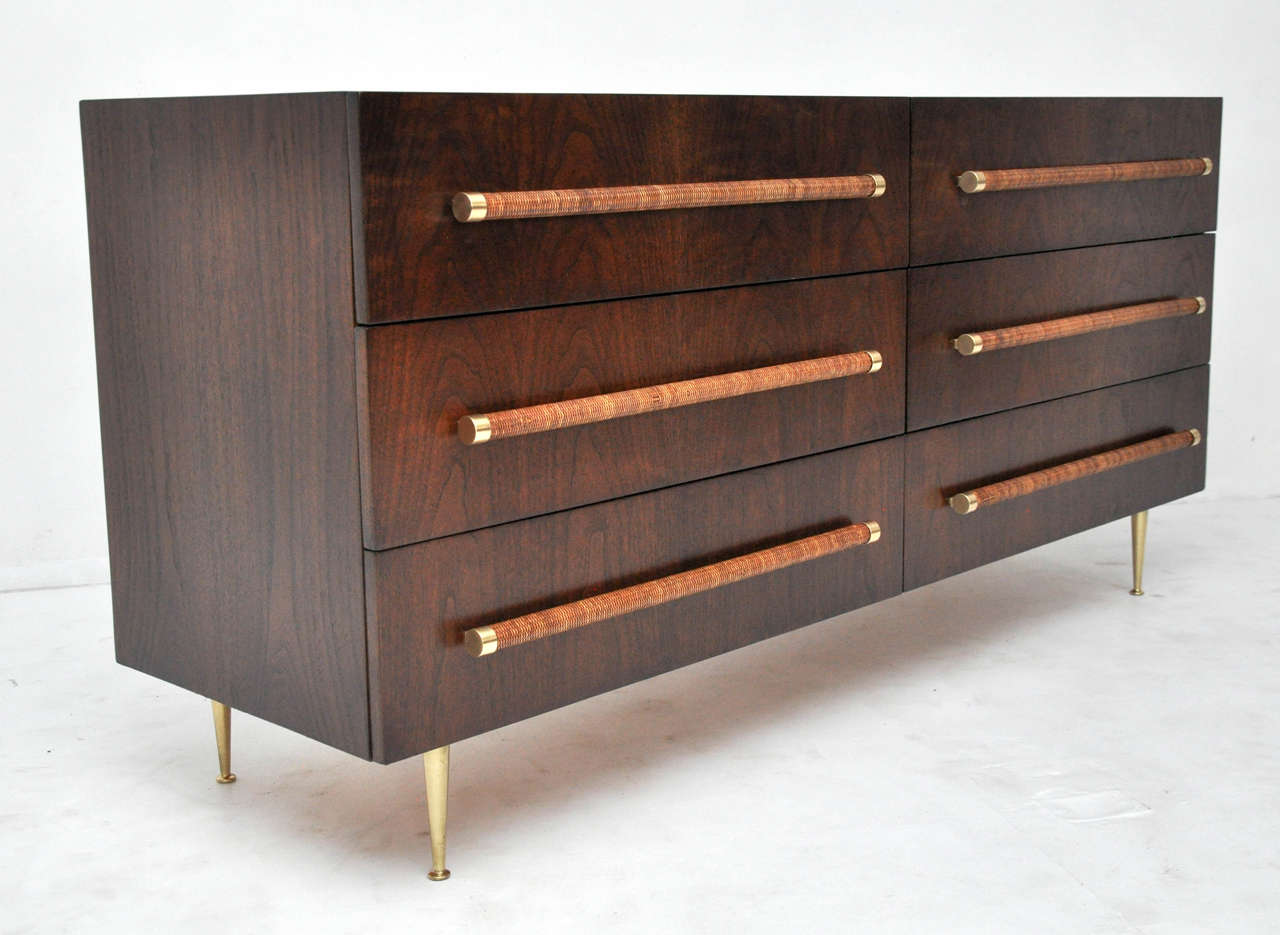 Beautiful six-drawer dresser designed by T.H. Robsjohn-Gibbings. Fully restored and refinished. Dark walnut finish with brass legs. Cane wrapped handles with brass detail.