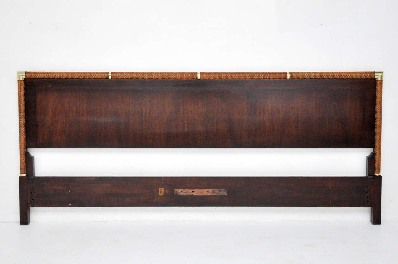 King-size headboard. Dark walnut finish with cane wrapped edge and brass details.