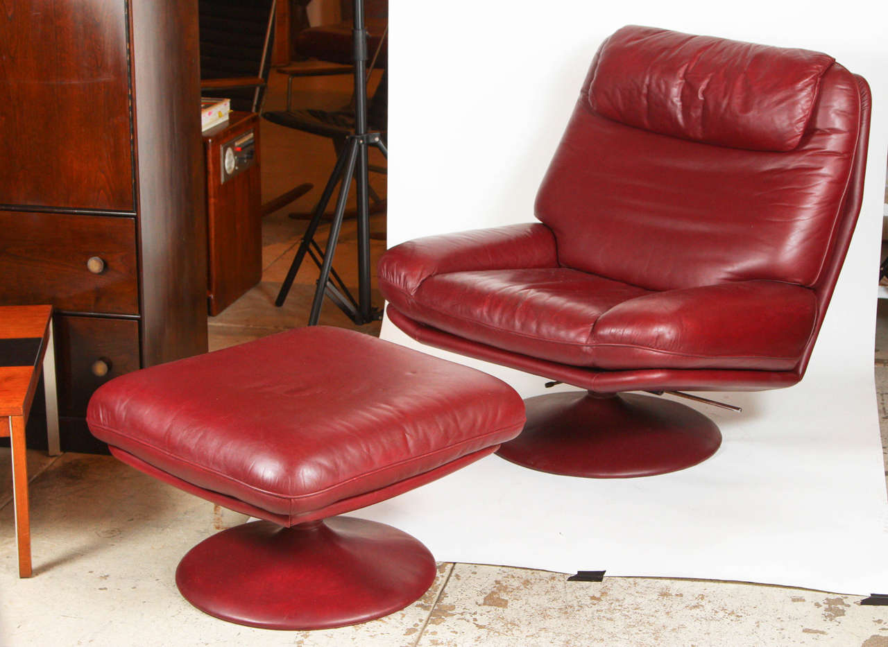 Pair of De Sede tilt or swivel armchairs and ottomans.
Wine leather with leather wrapped pedestals.
Note: Each ottoman measures: 24