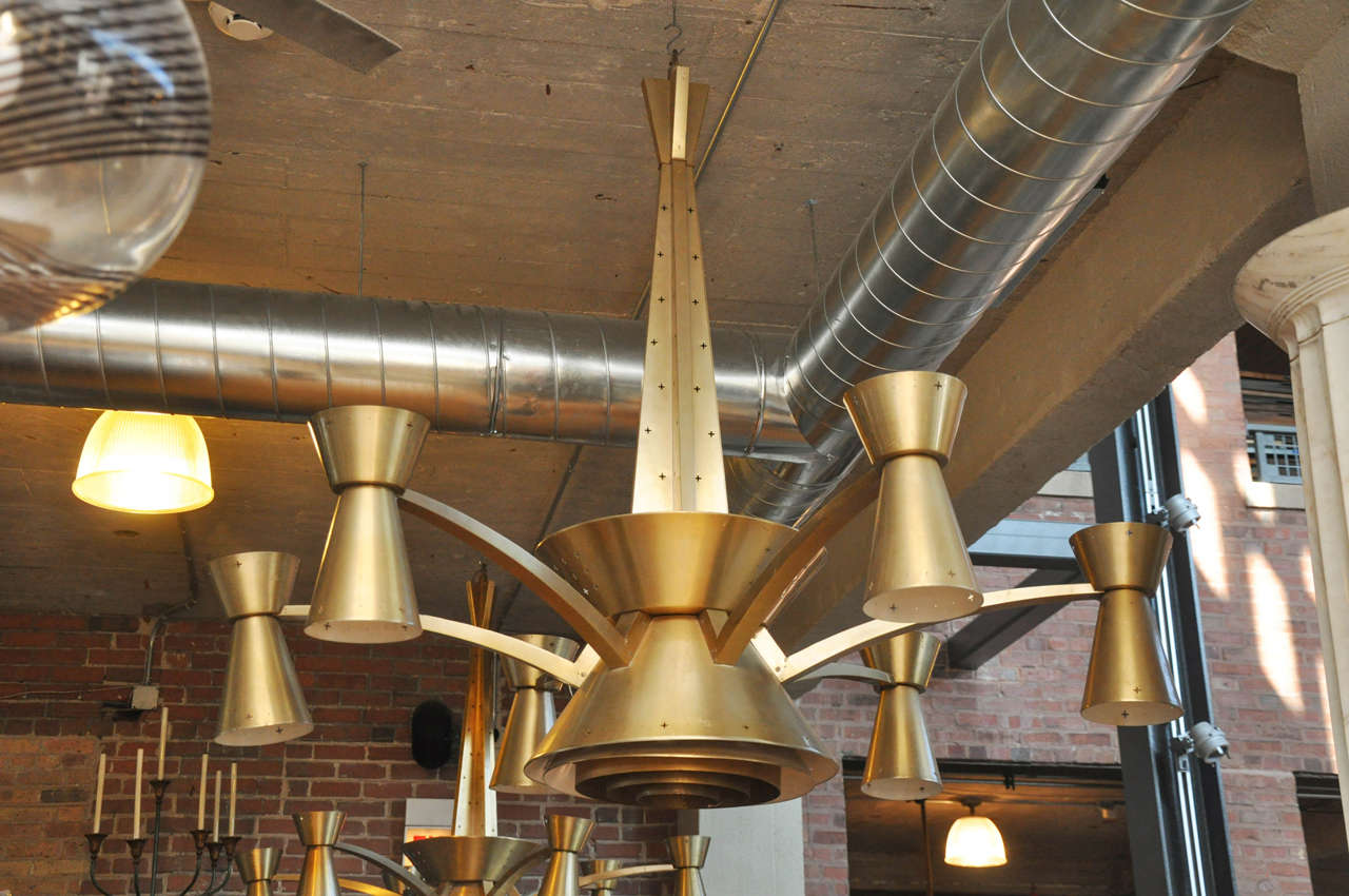 Mid-Century American brass chandelier with a lighted core and six arms, each with up and down lights.

Needs to be re-wired.