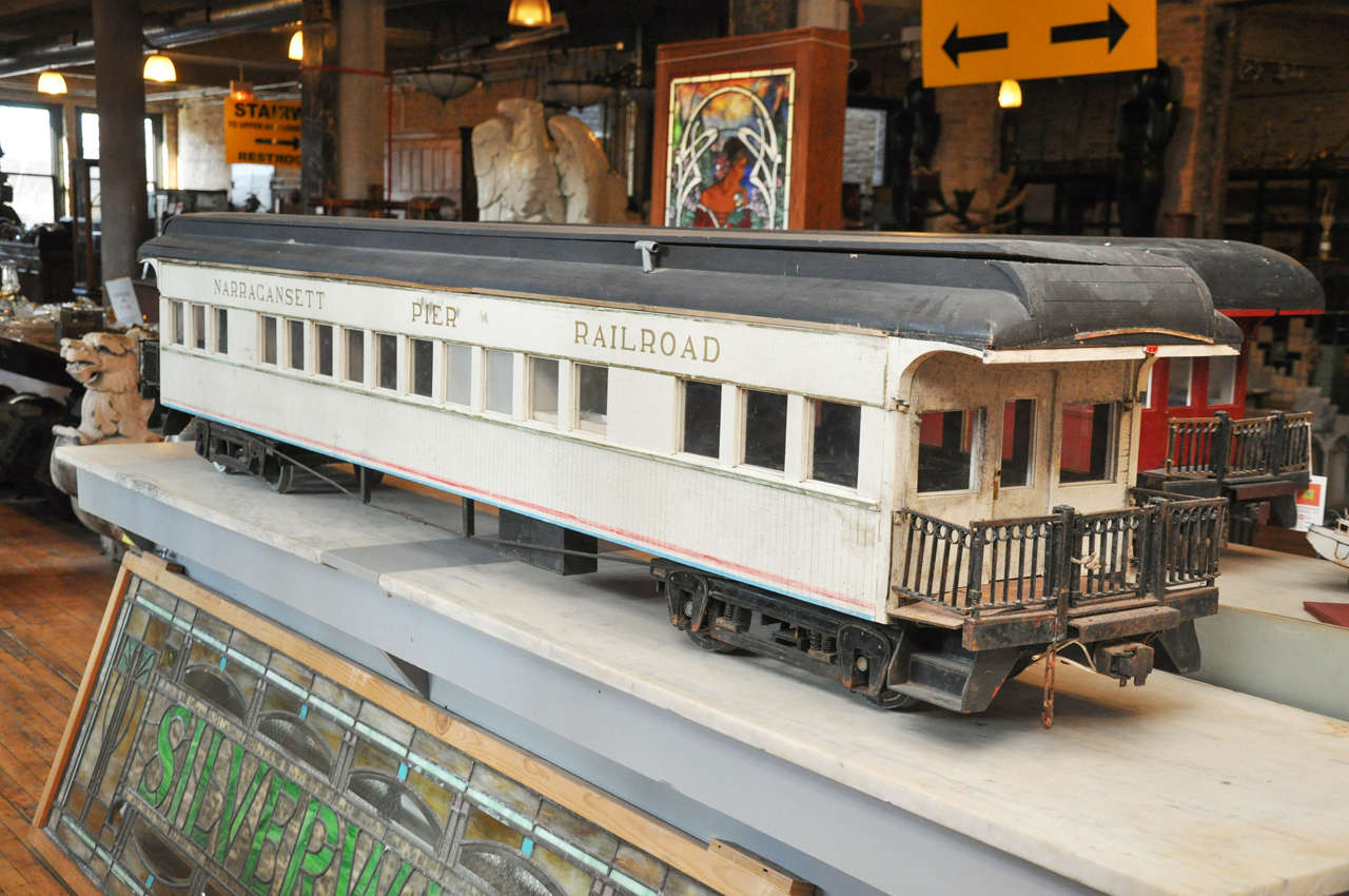 An early 20th century scale train model of a passenger car from the Narragansett Pier Railroad, complete with fully furnished rooms and wonderfully skilled wrought iron rails, gates and wheels.