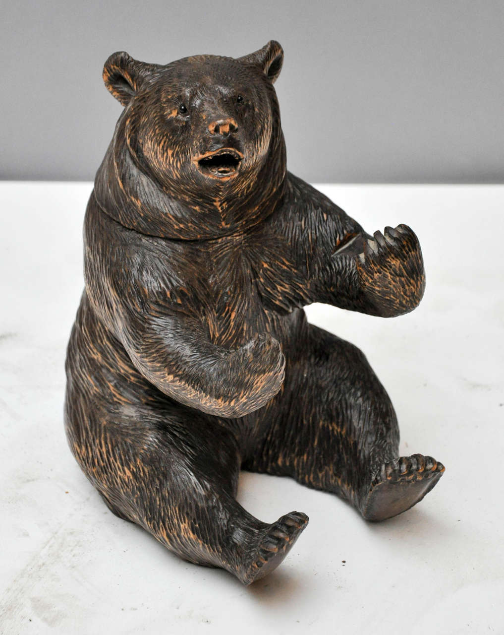 19th century Black Forest bear humidor. Intricately hand-carved sitting bear, hinged head reveals storage for tobacco, glass eyes and outstretched arms give life-like feel.