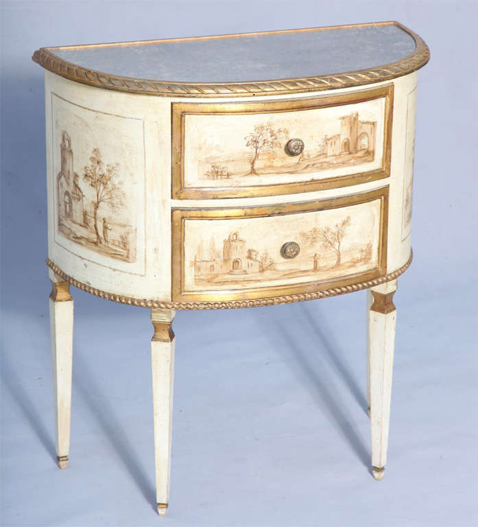Demilune commode, painted and parcel gilt; having a top of distressed mirror in gadrooned border, over two drawers, each hand painted with Italianate landscapes and similarly painted sides, raised on square-section tapering legs.
