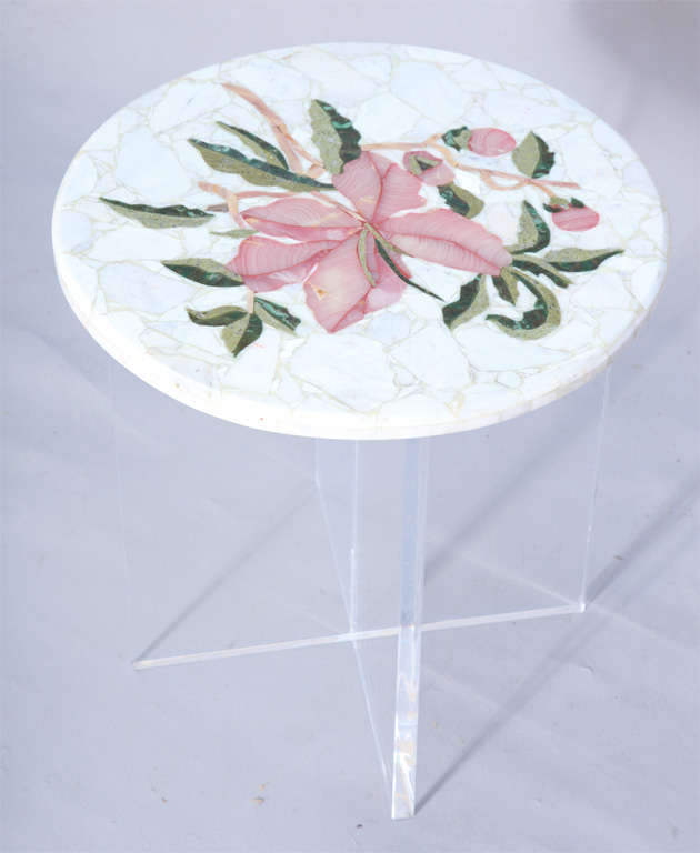 Accent table, having a round pietre dura top of marble inlaid into a pattern of a flower, raised on lucite X-base.<br />
<br />
(Keywords: Side Table, Cigarette Table)