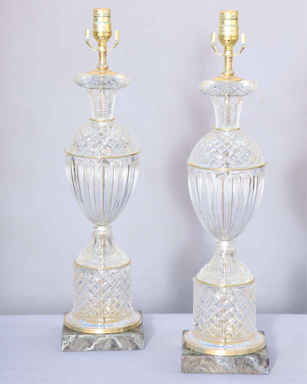 Pair of urn shaped glass lamps, in Baccarat style, of fluted and cross hatch glass, on square black veined marble base.  By Warren Kessler.