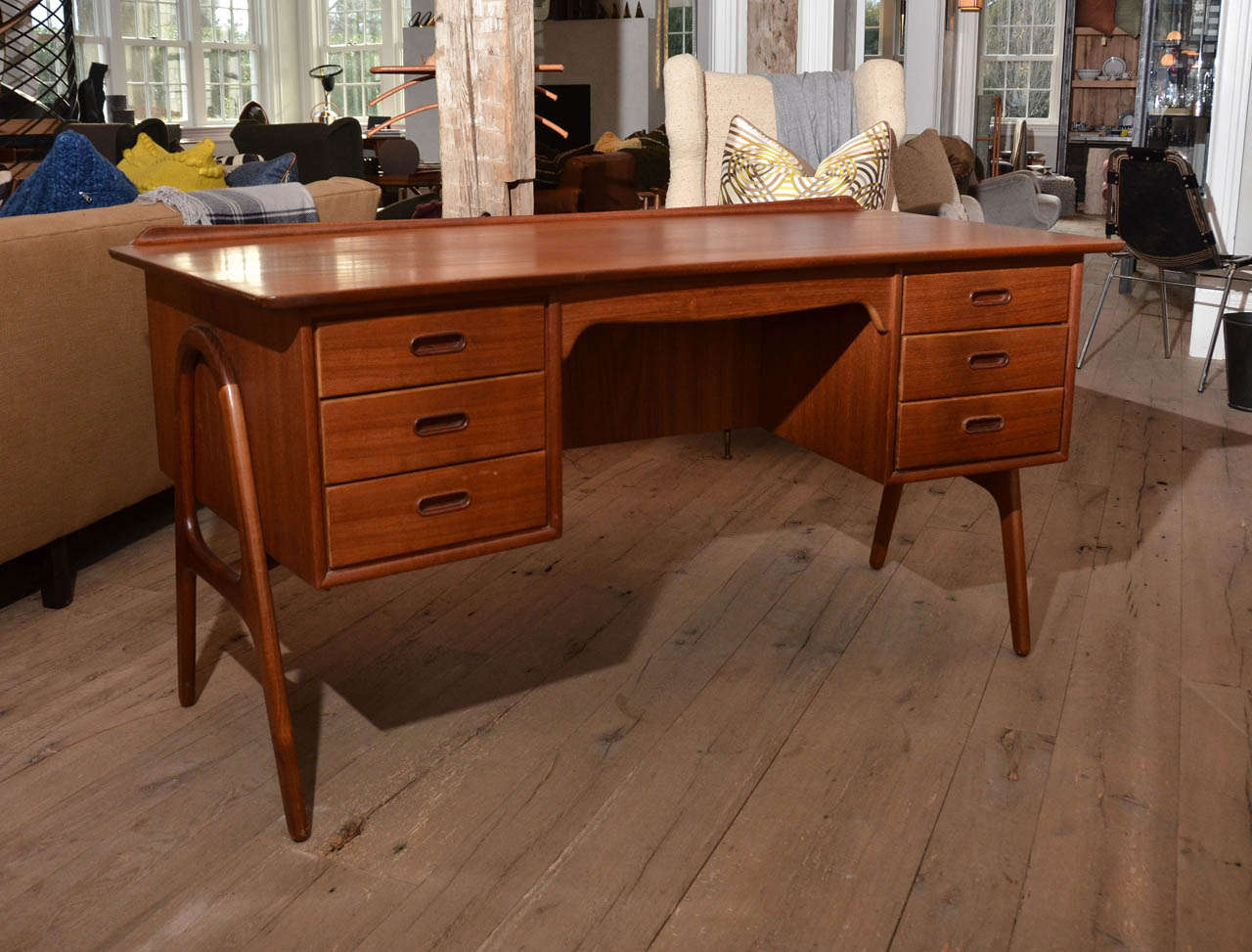 Beautiful crafted 1960's Danish teak desk by Svend Aage Madsen it features three drawers on each side which allows for maximum storage . With an integrated book shelve on the front, it makes this desk a perfect standalone piece. Curved teak legs add
