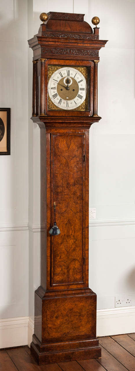 This superb George I period antique longcase clock by Daniel Delander is cased in highly figured walnut veneer of lovely colour and patina. Standing on a double plinth there is a panelled base and moulded trunk door. The pull forward hood is flanked