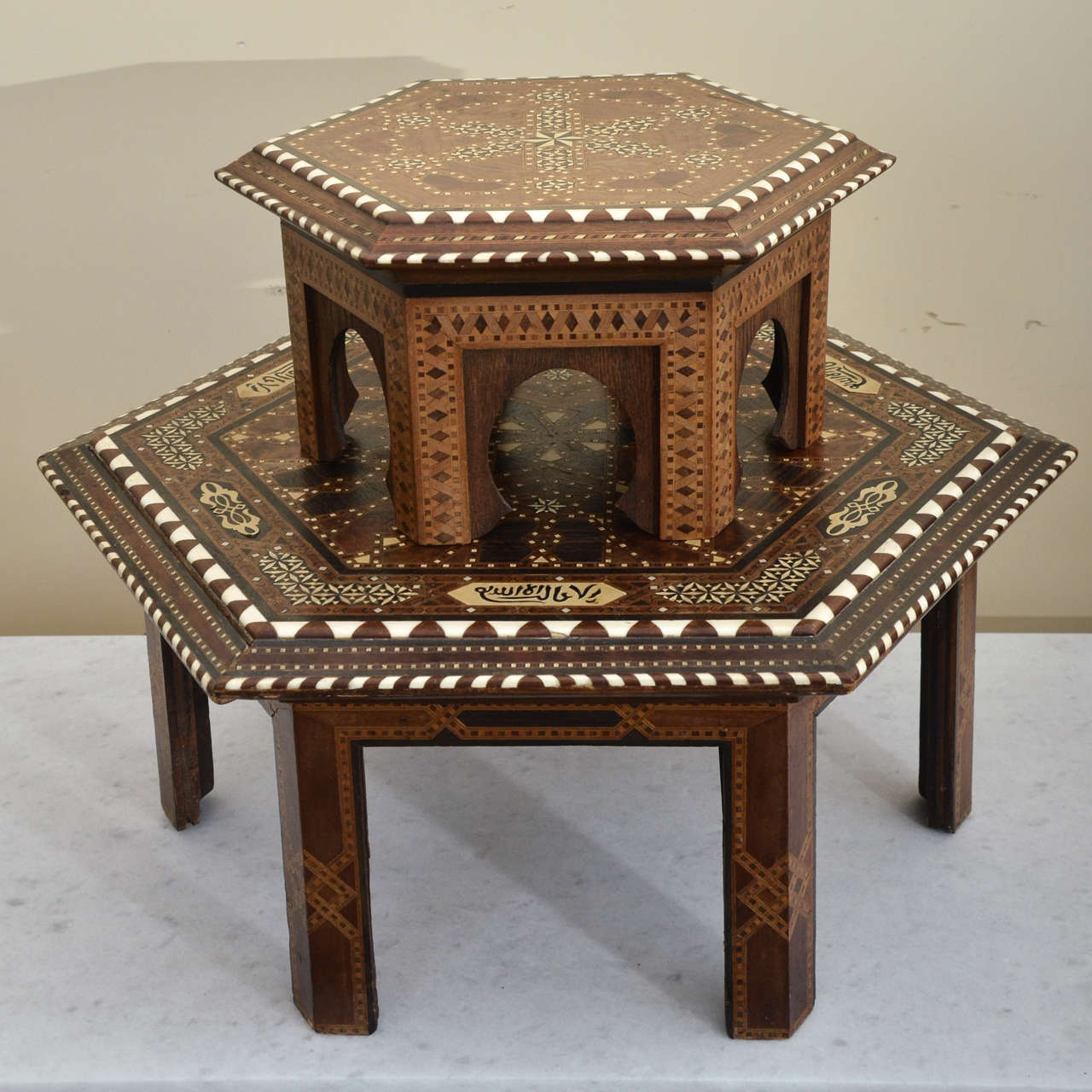 Stacking Middle Eastern inlaid tables. The smaller table has inlaid star patterns throughout the top, with saw tooth design in ivory at the edge. The dimensions are 14