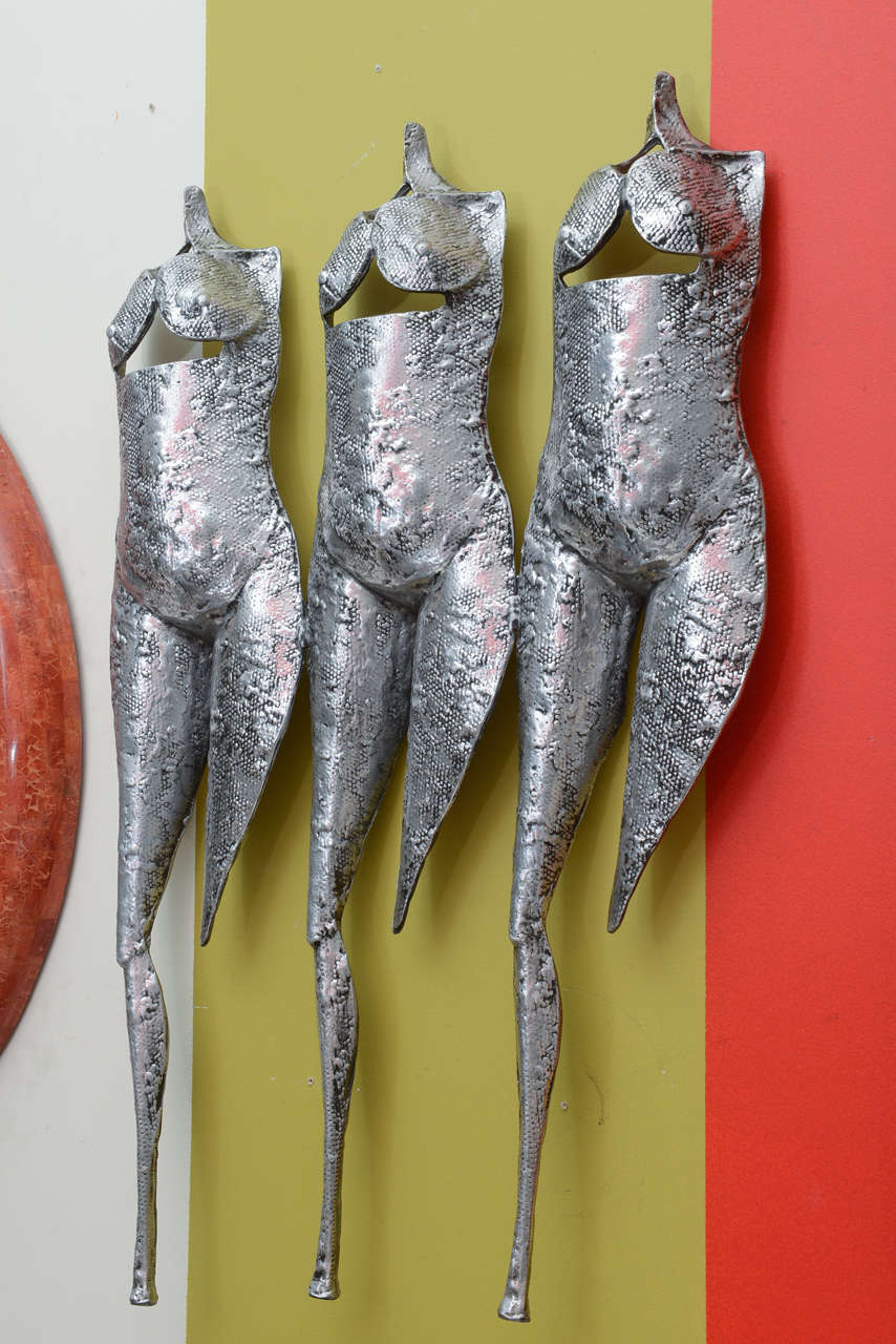 This unusual dramatic, conversational and Brutalist female muse vintage monumental wall sculpture is arresting. It is cast aluminum with a painted black patina wash that has a dimpled finish. It looks like white bronze. It is three torsos, in