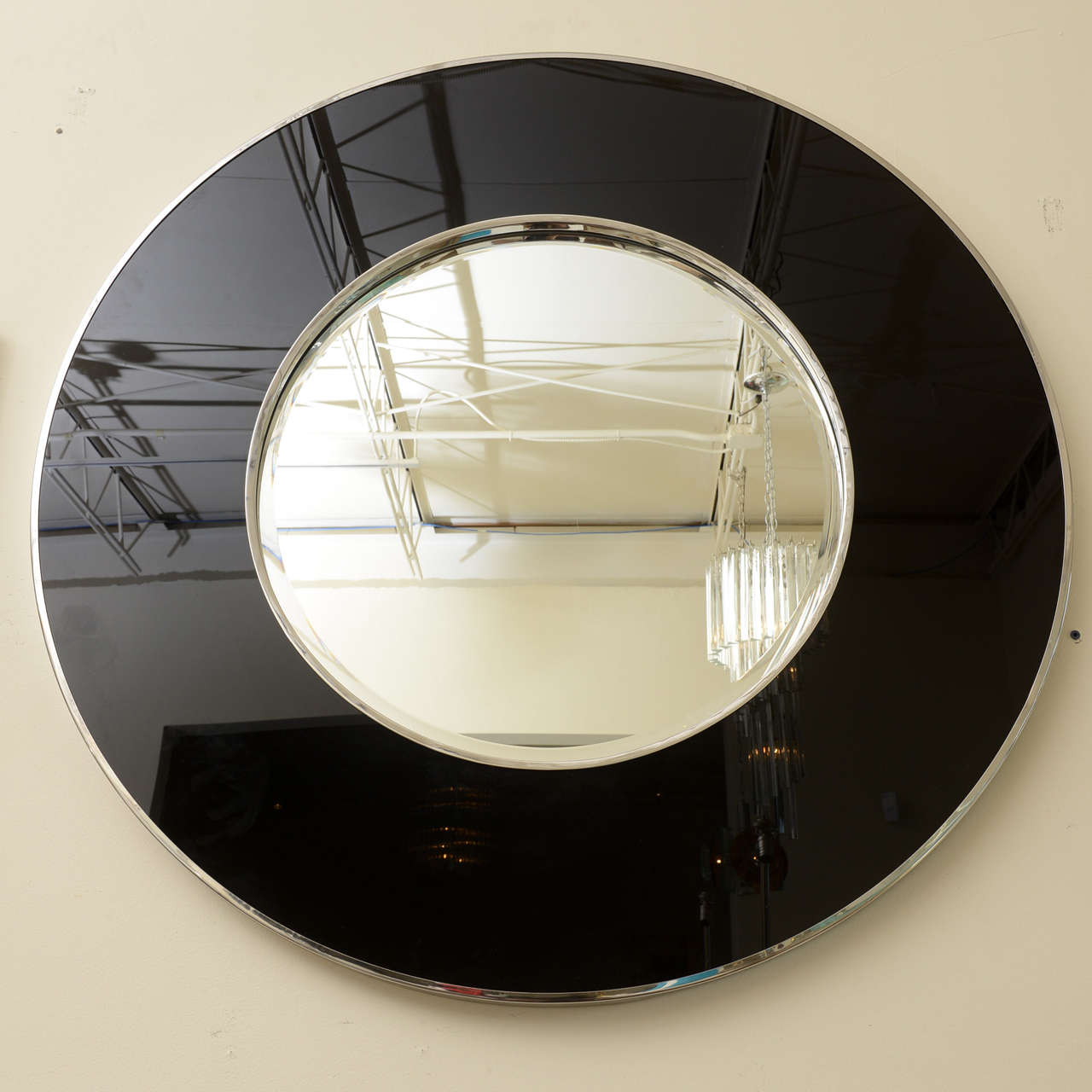 This chic, timeless, modern and arresting black glass and stainless steel mirror makes an entrance to a room. The stainless steel has the inner band and the outer band surrounded by the black glass and the mirror in the center.
Very well made from