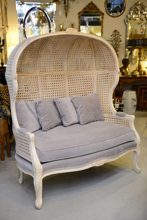 Very unusual and charming hooded loveseat.  Off white painted and carved frame with double caning.