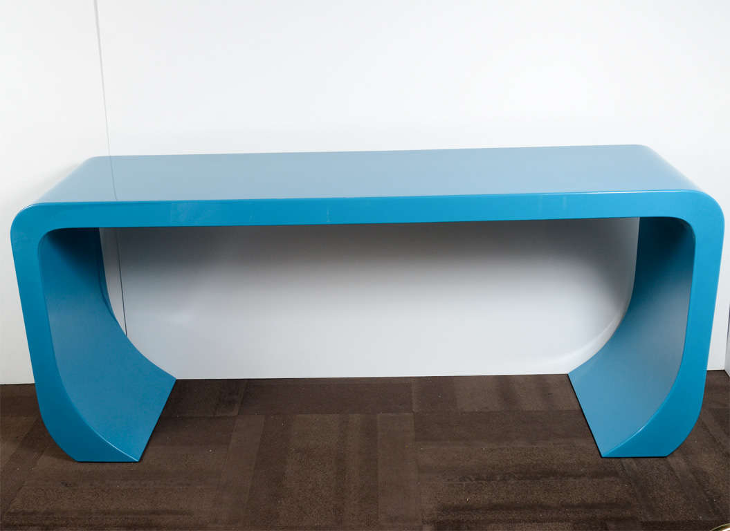 Exceptional midcentury console table or sofa table with waterfall form. The table has a modernist Asian inspired design with legs that curve inward, and has been finished in a brilliant turquoise or peacock blue lacquer.