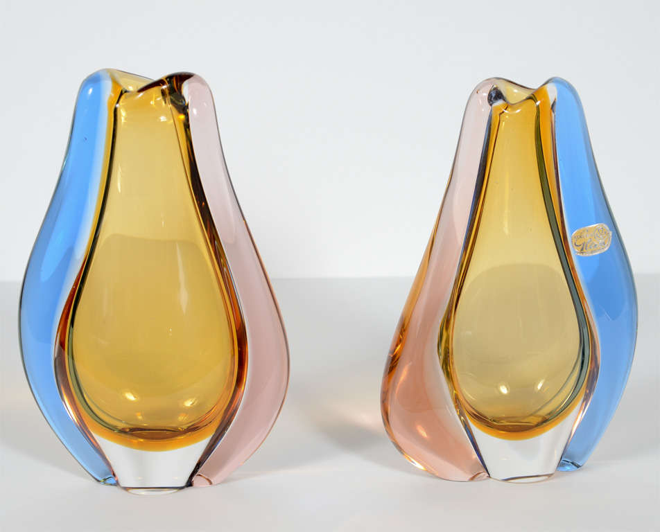 Pair of beautiful vases with stylized tear drop or modernist tulip form. The vases are cased and handblown. They are comprised of amber glass centers with clear glass bases, and sides of deep blue and violet colored glass. Make great decorative