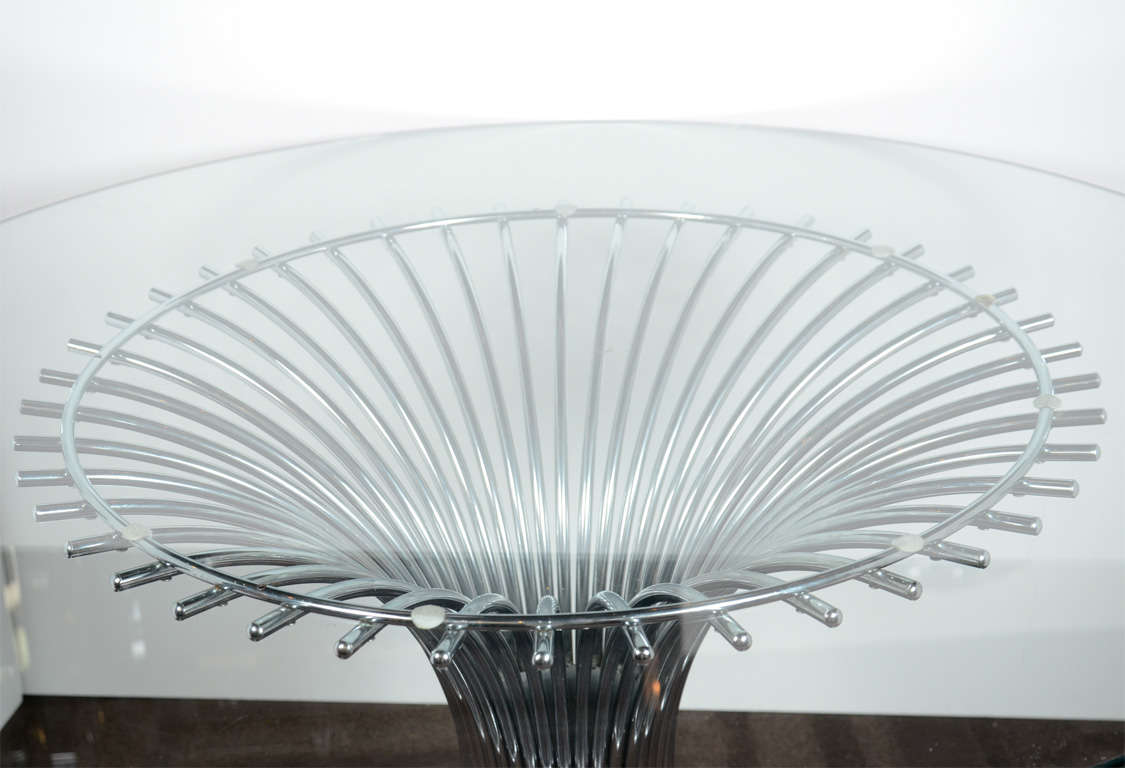 Mid Century dining table has a sculptural tubular chrome base with a tulip form, and features a circular hand beveled glass top. Distinguished design exemplary of Modernism and architecture of the 1960's, and in the style of Warren Platner.  