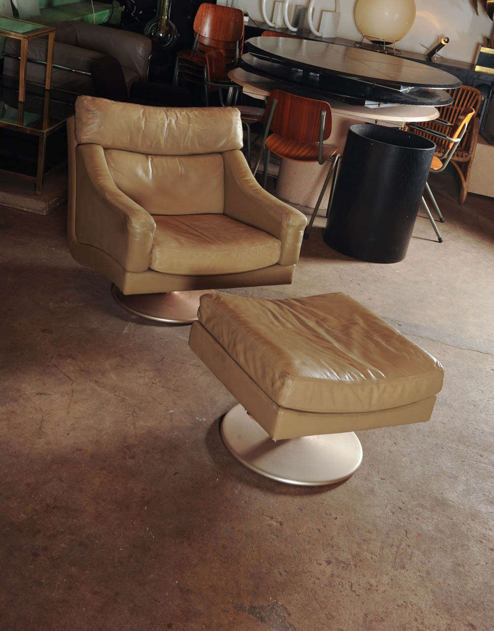 Very comfortable set of a beautiful tanned leather lounge chair and it's hocker. Rathe rin the style of Clockwork Orange. They both swivel on a distinctive trumpet shaped base. Although it looks like it, it is is not by De Sede; but it is a very
