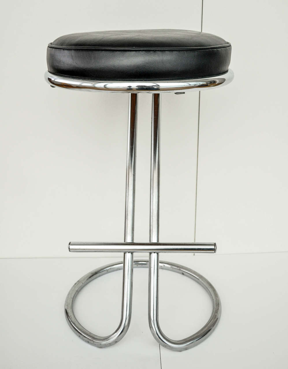 An iconic, counter or bar stool of chrome-plated tubular steel by Industrial designer Gilbert Rohde for Troy Sunshade. Rohde (1894-1944) was an early advocate for American Modernism. Both functional and flexible, his 