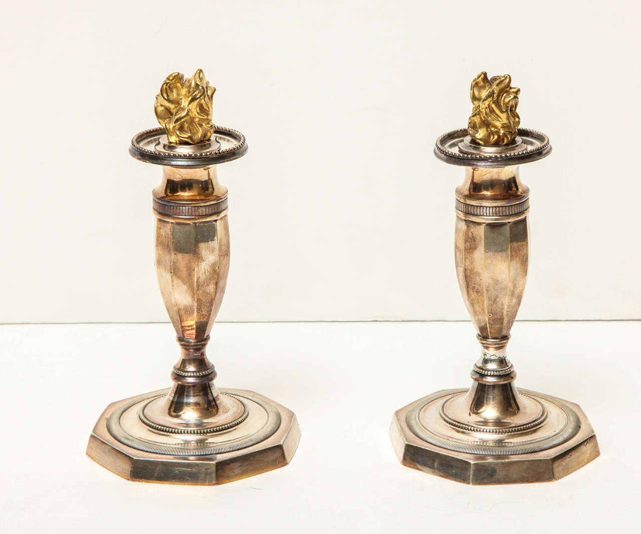 Pair of Directoire Silver Candlesticks With Gold Flames.  The Body is Hexagonal Shaped and Tapers to a Hexagonal Base With Coin Edge Decoration.